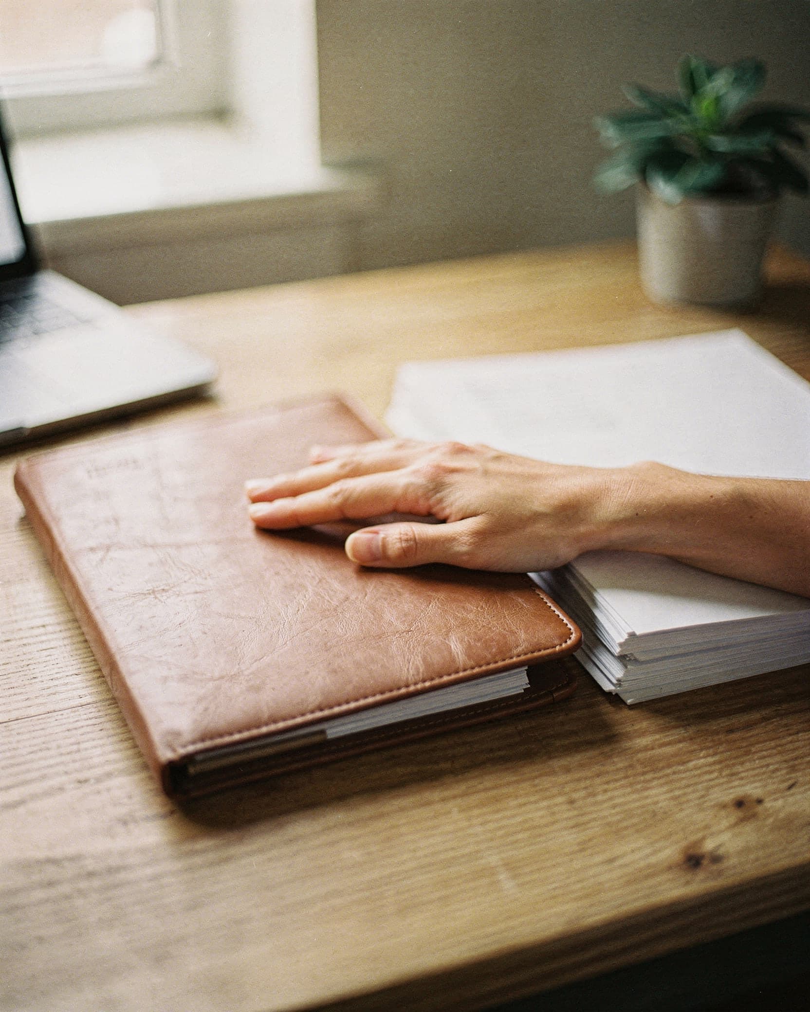 Des mains classent des documents administratifs sur un bureau