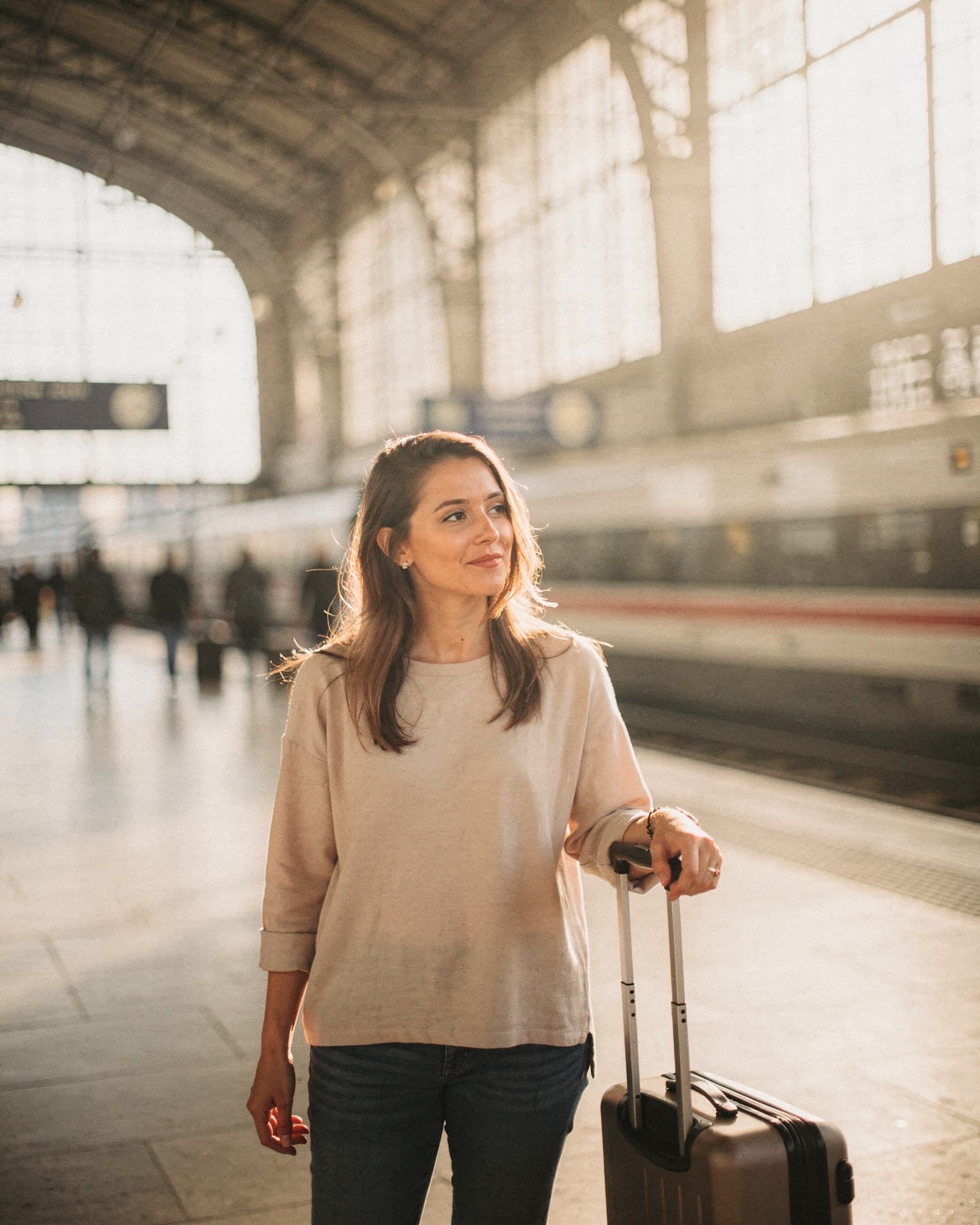 Camille, soprano, dans le hall d'une gare avec sa valise